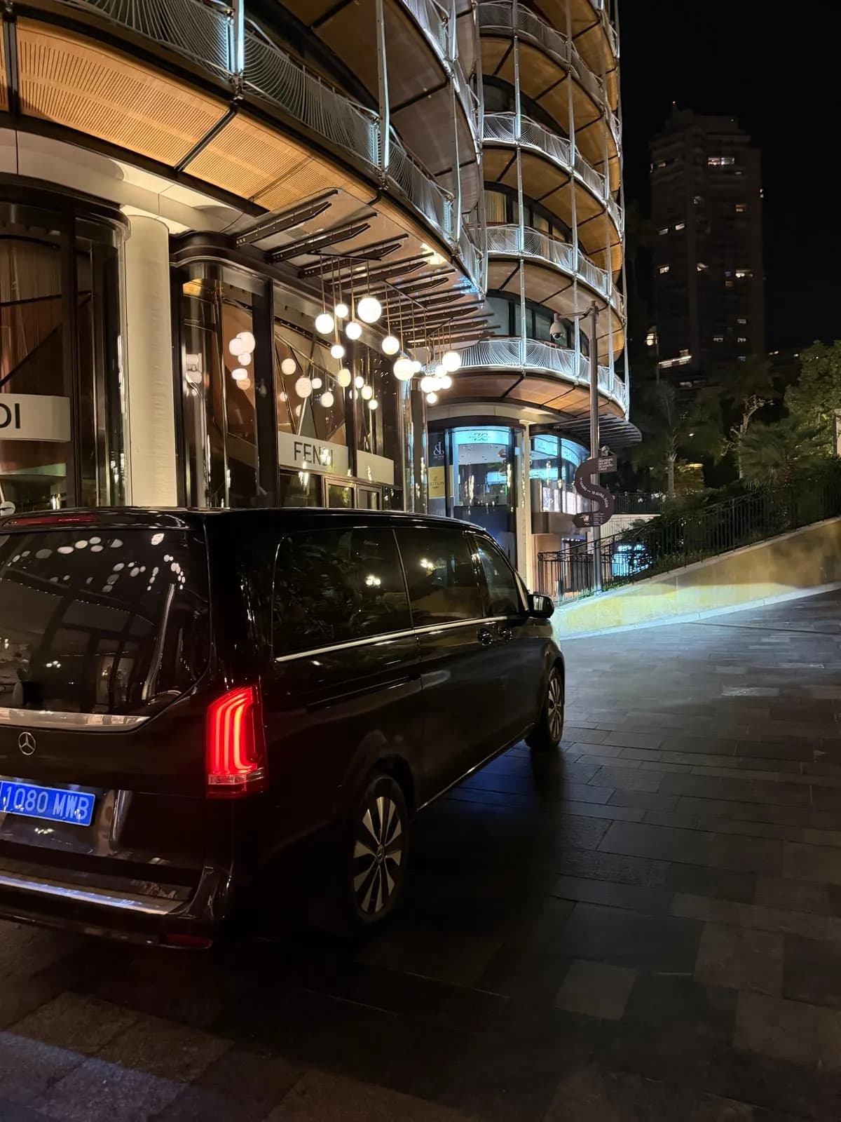AurelTransfers Mercedes V-Class on a luxury seafront promenade at night